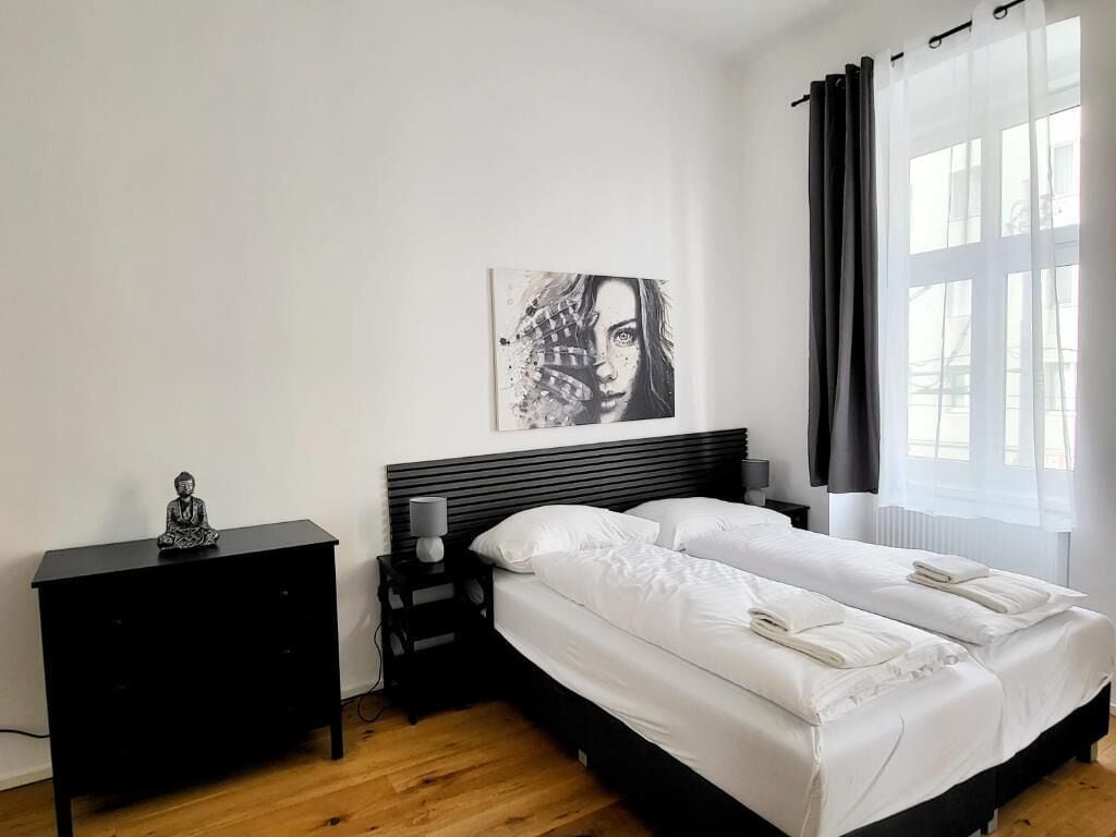 A bedroom with a double bed, a bedside table, a lamp, and a wall-mounted artwork.