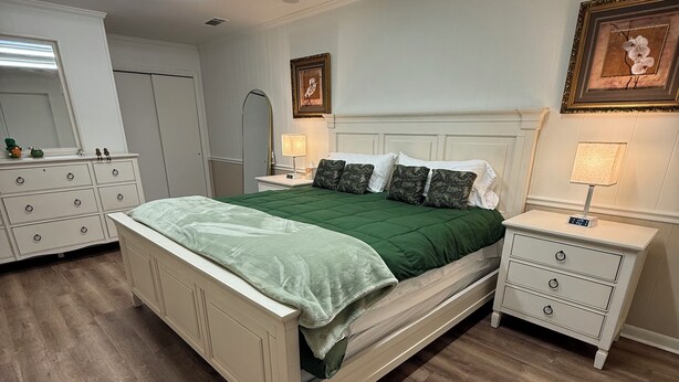 Une chambre à coucher avec un lit, des tables de chevet, une commode et un miroir.