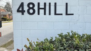 Un mur blanc sur lequel est inscrit en lettres noires le numéro « 48HILL ».