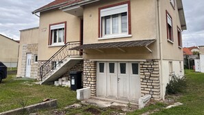 A two-story house with a red-tiled roof, a front staircase, and a garage. - Maison Carpe Diem Maximum Pour 4 Personnes (Romilly-sur-Seine)