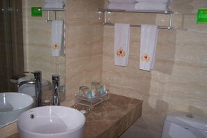 Ein Badezimmer mit zwei Waschbecken, einem Spiegel, einem Handtuchhalter mit Handtüchern und einer Seifenspender.