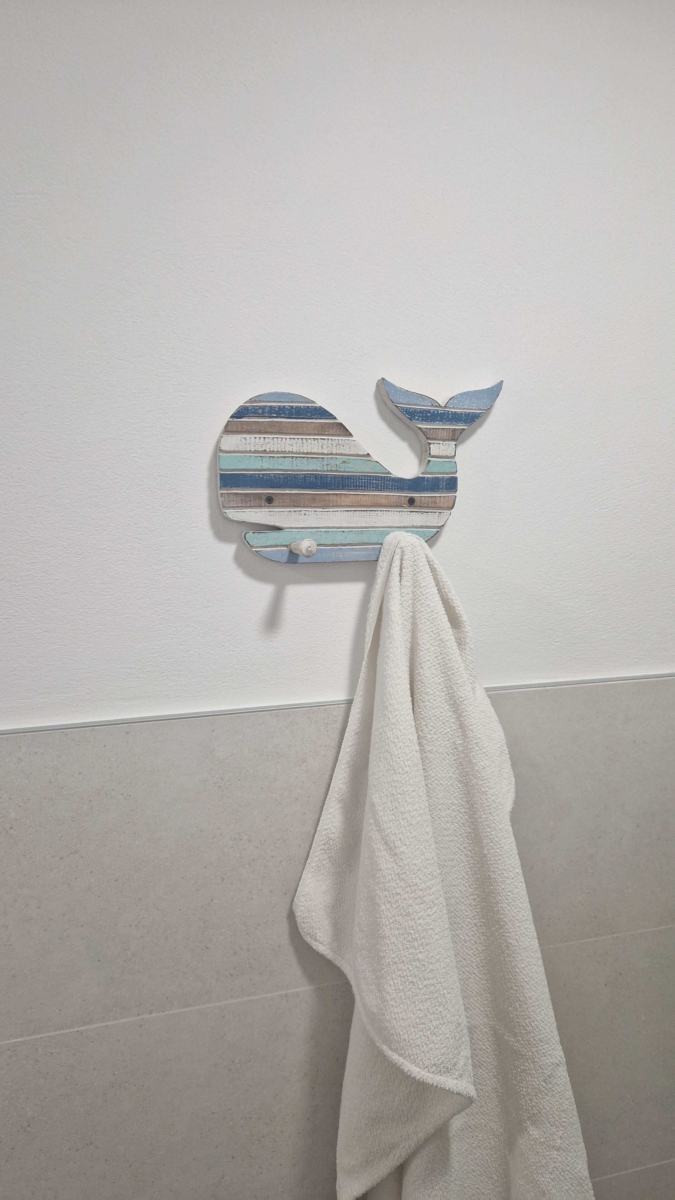 Ein Badezimmer mit einem an der Wand befestigten Handtuchhalter.