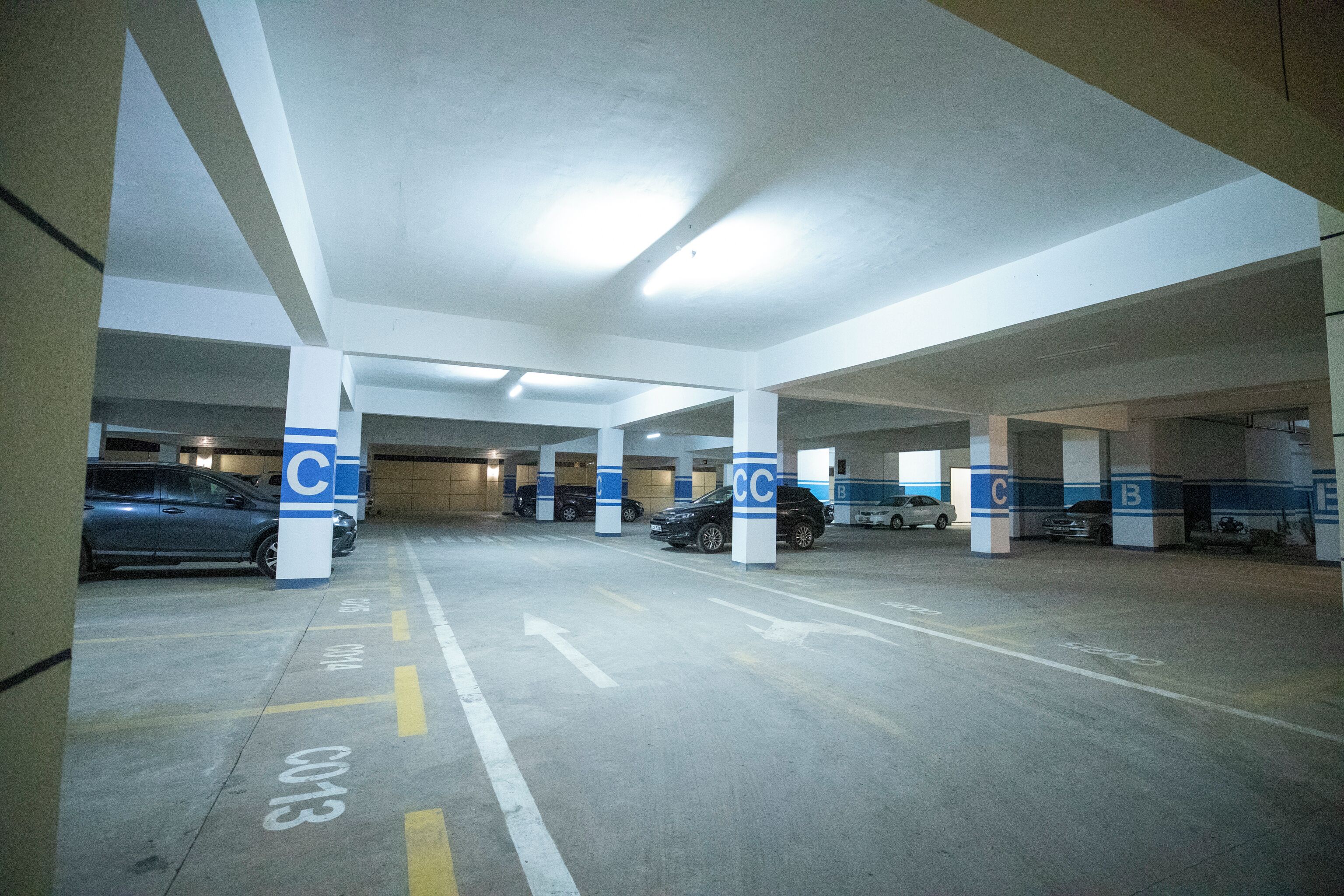 A multi-level parking garage with clearly marked parking spaces and directional arrows.