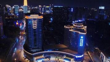 A high-rise building with a curved entrance and illuminated signage.