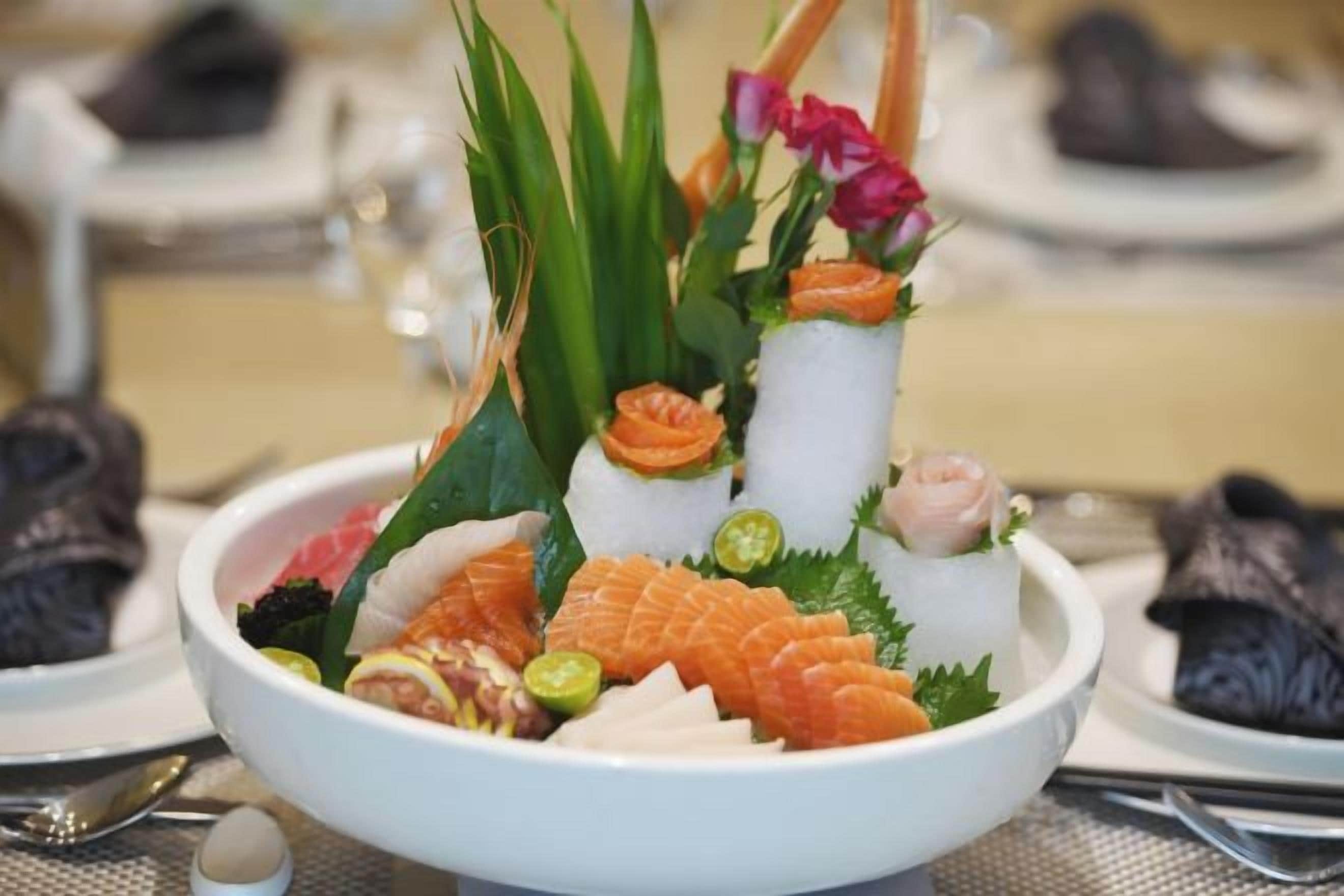 A bowl of sushi with various types of fish and garnishes.