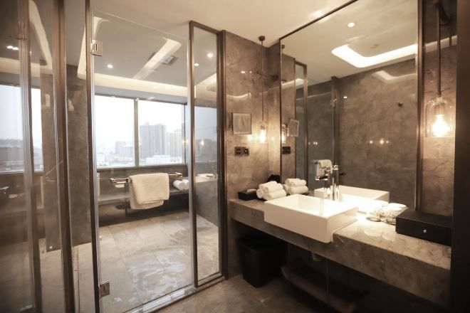 A modern bathroom with a glass shower enclosure, a large mirror, and a dual sink vanity.