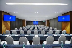 A conference room with rows of tables and chairs, equipped with water bottles and nameplates. - Future Hotel (Zhengzhou)