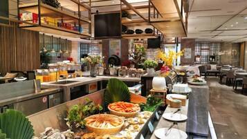 A buffet area with seafood, a kitchen in the background, and a seating area with tables and chairs.