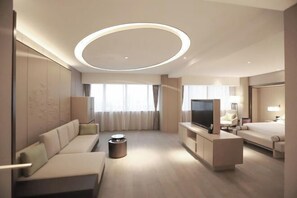 A modern hotel room with a sofa, TV, and a bed. - Future Hotel (Zhengzhou)