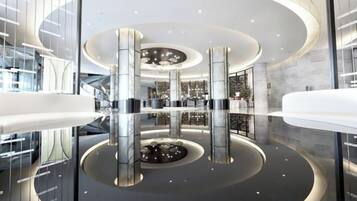 A modern lobby with a circular design, glass railings, and a central reflective feature.