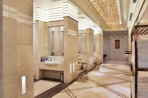Un baño amplio con varios lavamanos, tocador y espejo.