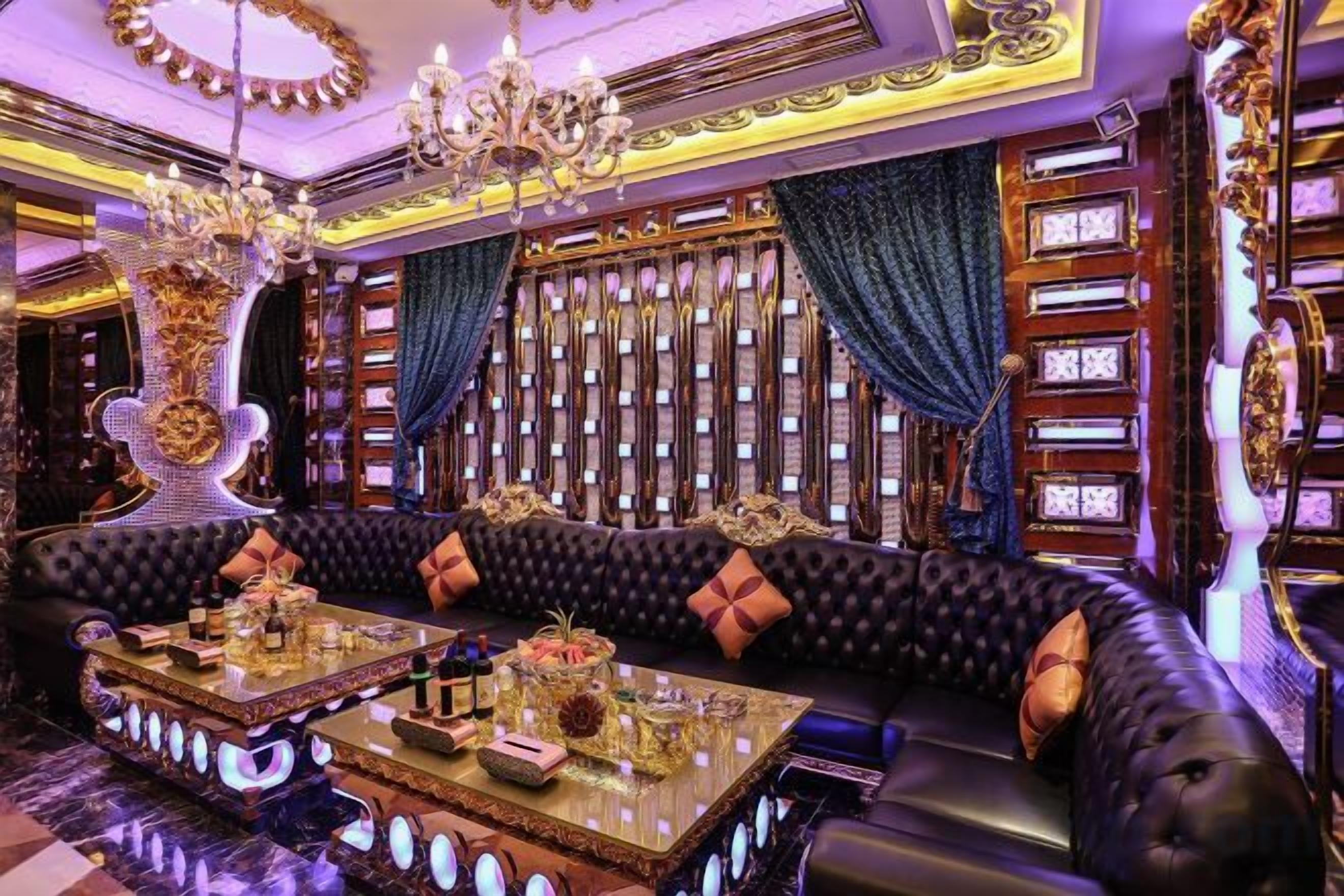 Uma sala de estar luxuosa com um sofá de couro preto, uma mesa de centro de vidro e decoração requintada.