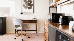 Ein moderner Arbeitsraum mit Schreibtisch, Stuhl und Küchengeräten.