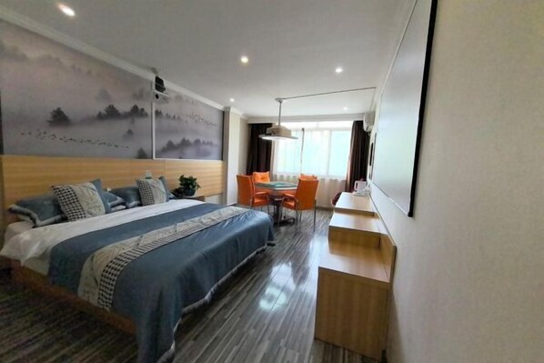 A hotel room with a bed, a desk, a chair, and a large window. - Tongling Weiduo Garden Hotel (Tongling)