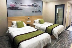 A hotel room with two beds, a wooden headboard, a painting on the wall, and a door. - Tongling Weiduo Garden Hotel (Tongling)