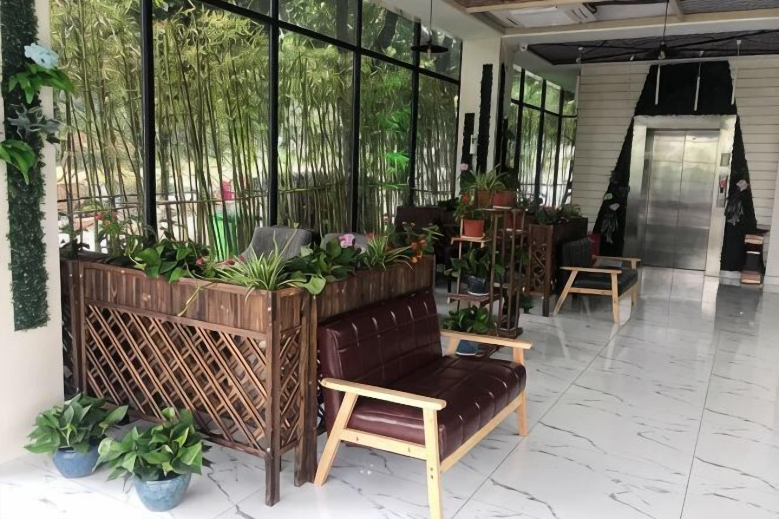 Un vestíbulo con un banco de madera, plantas en macetas y un piso de mármol.