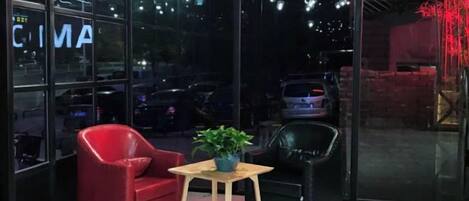 A seating area with a red chair, a black chair, and a small table with a plant.