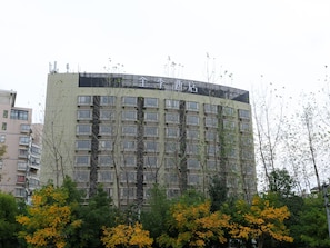Un immeuble à plusieurs étages, doté d’un toit plat, de nombreuses fenêtres et d’une enseigne indiquant qu’il s’agit d’un hôtel.