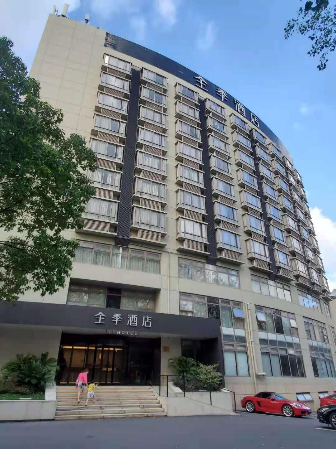 Um hotel com vários andares, entrada imponente, varandas e céu claro.