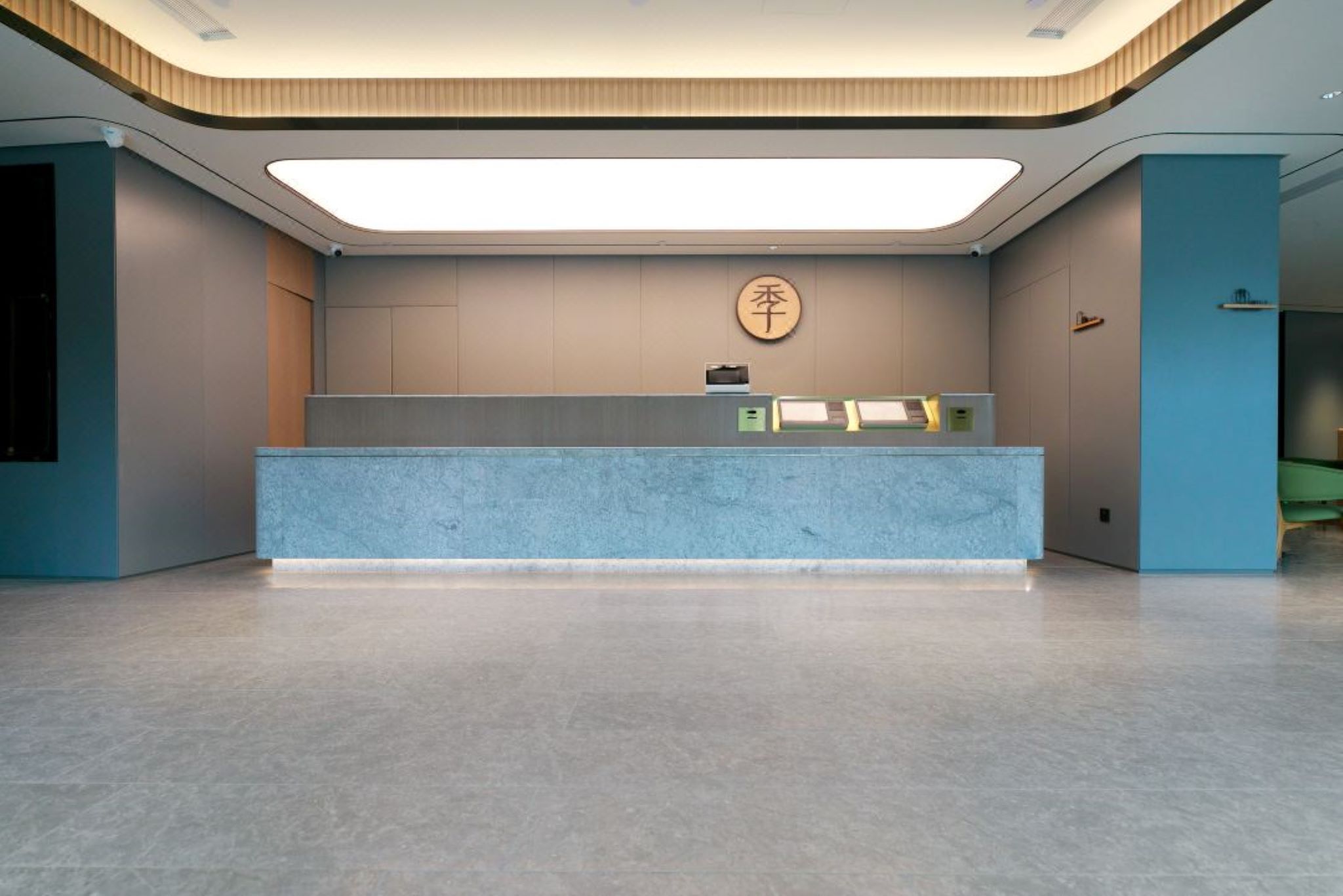 Uma receção com design moderno, um sinal com caracteres chineses fixado na parede e um interior limpo e minimalista.