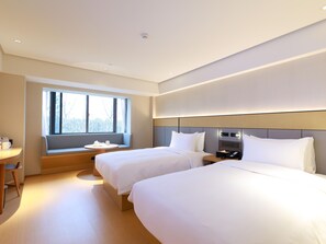 A hotel room with two beds, a seating area with a table, and a large window. - Ji Hotel (Shanghai)