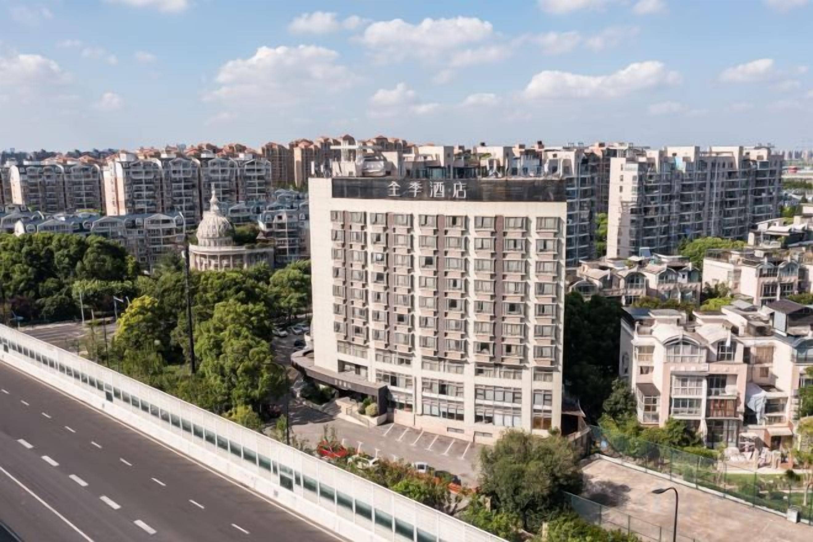 A multi-story hotel with a prominent dome structure, surrounded by a dense urban environment.