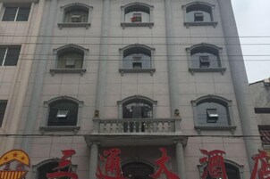 Un edificio con varias ventanas y un letrero grande con caracteres chinos.