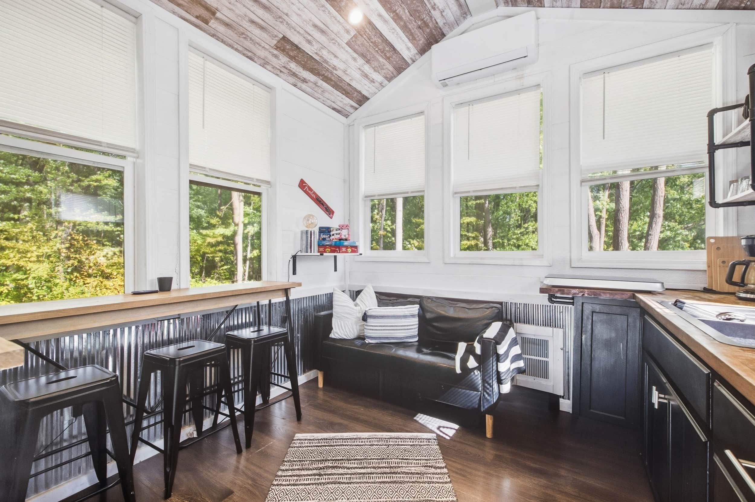 Una cocina moderna con ventanas amplias, una barra y un espacio de estar acogedor.