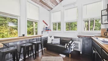 Una cocina moderna con ventanas amplias, una barra y un espacio de estar acogedor.