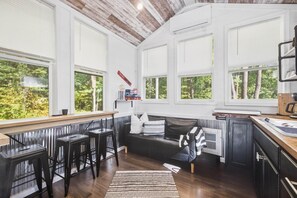 Een moderne keuken met grote ramen, een bar en een gezellige zithoek.