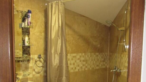 Un baño con ducha, inodoro y lavabo.