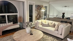 A living room with a round coffee table, a sofa, and a patterned rug.