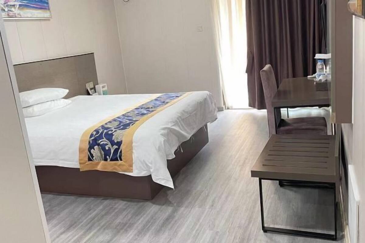 Une chambre d’hôtel avec un lit, une table et une chaise.