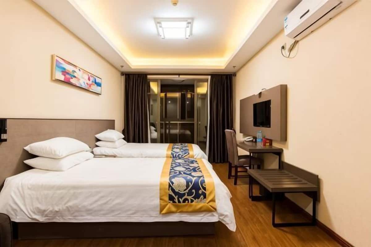 Une chambre d’hôtel équipée d’un grand lit, d’un bureau, d’une chaise, d’une télévision et d’un appareil de climatisation.