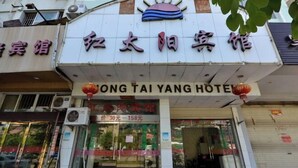Un hotel con un letrero que dice "Hong Tai Yang Hotel" y un precio de 158 yuanes.