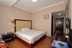A hotel room with a bed, a bedside table, a lamp, a TV, and a door leading to another room. - Hong Tai Yang Hotel (Yuhuan)