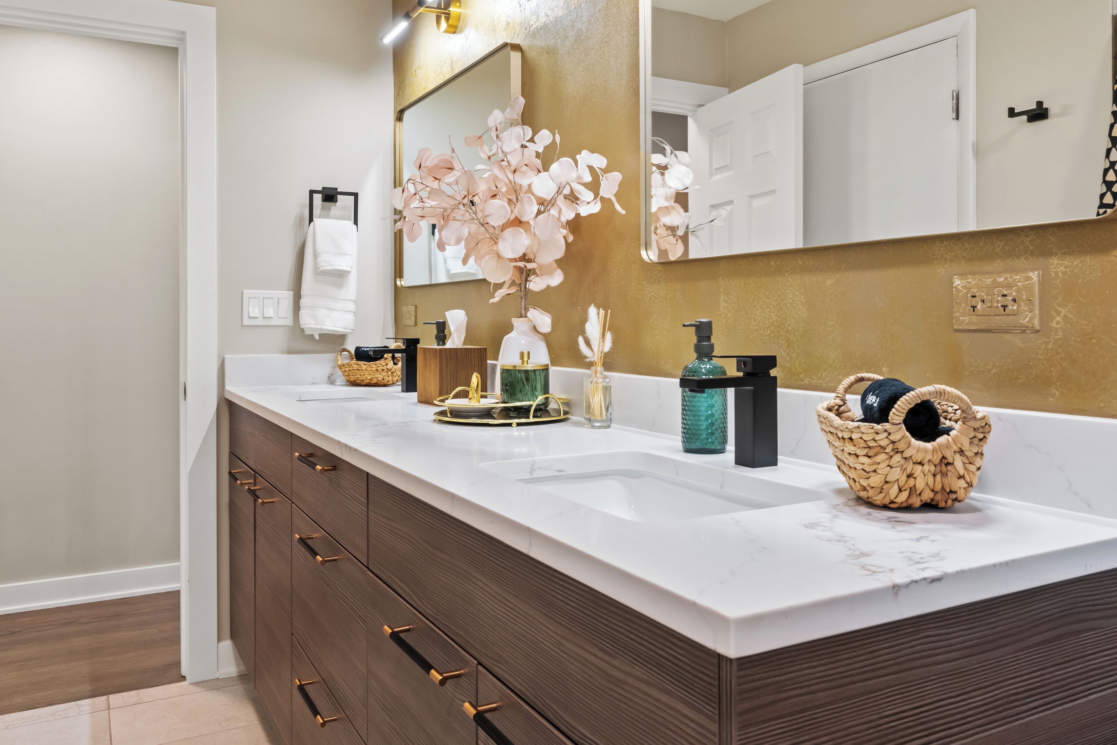 Une salle de bain avec un lavabo blanc, un miroir et un meuble en bois.