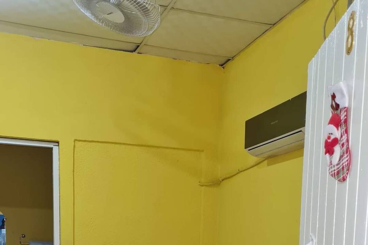 A room with a bed, a white wardrobe, and a door leading to a bathroom.