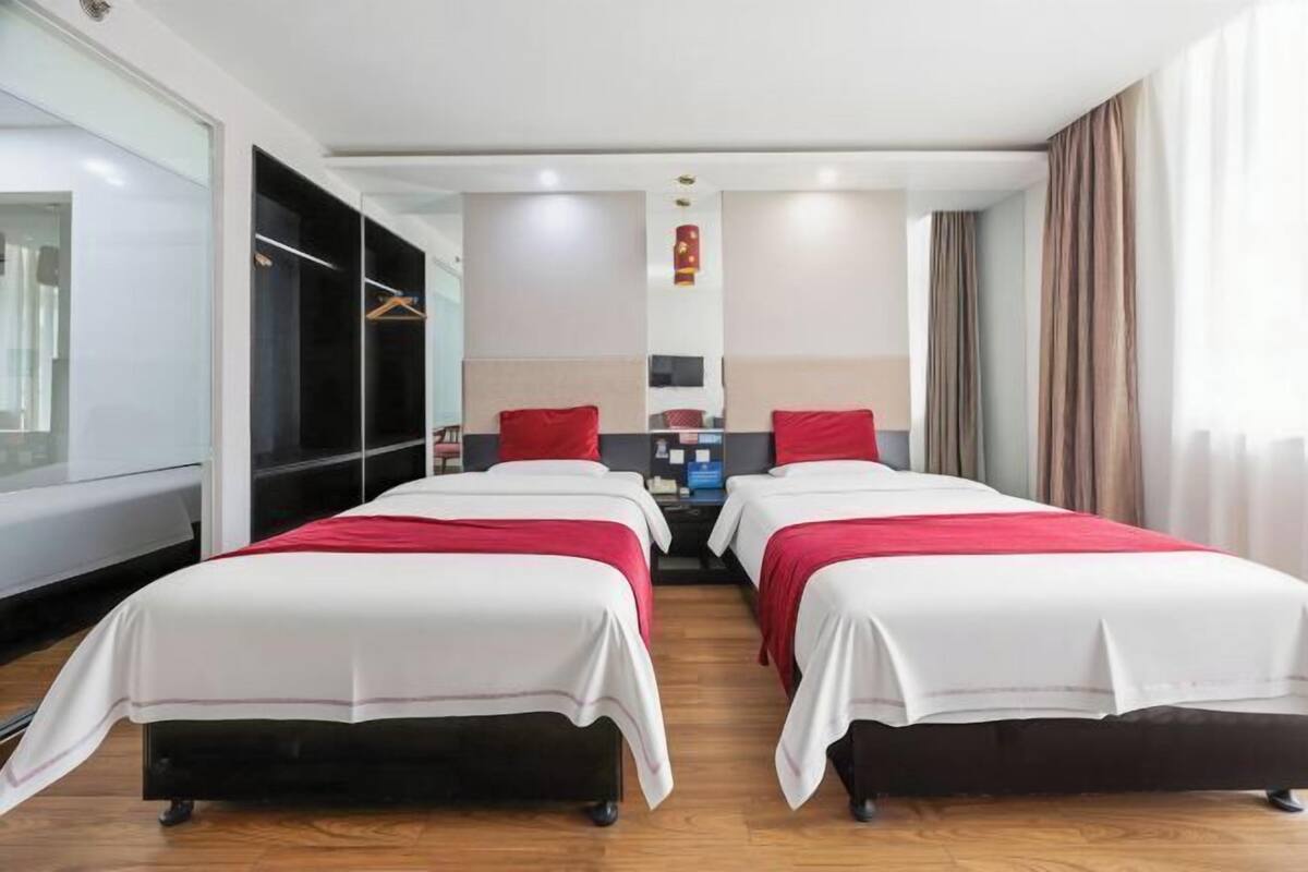Una habitación de hotel con dos camas, un escritorio y un armario.
