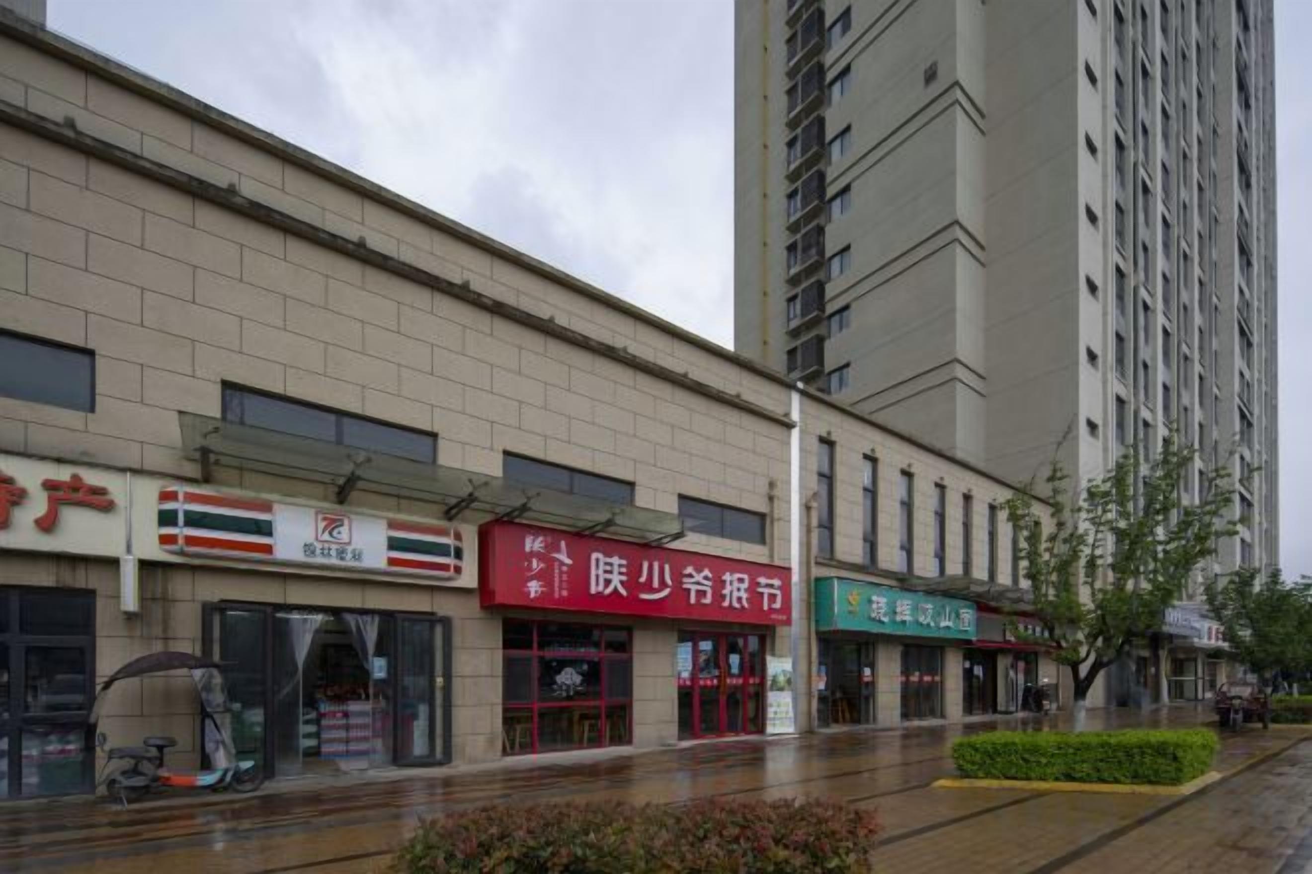 Ein Geschäftshaus mit mehreren Läden, darunter eine Bank, ein Restaurant und ein Kiosk.