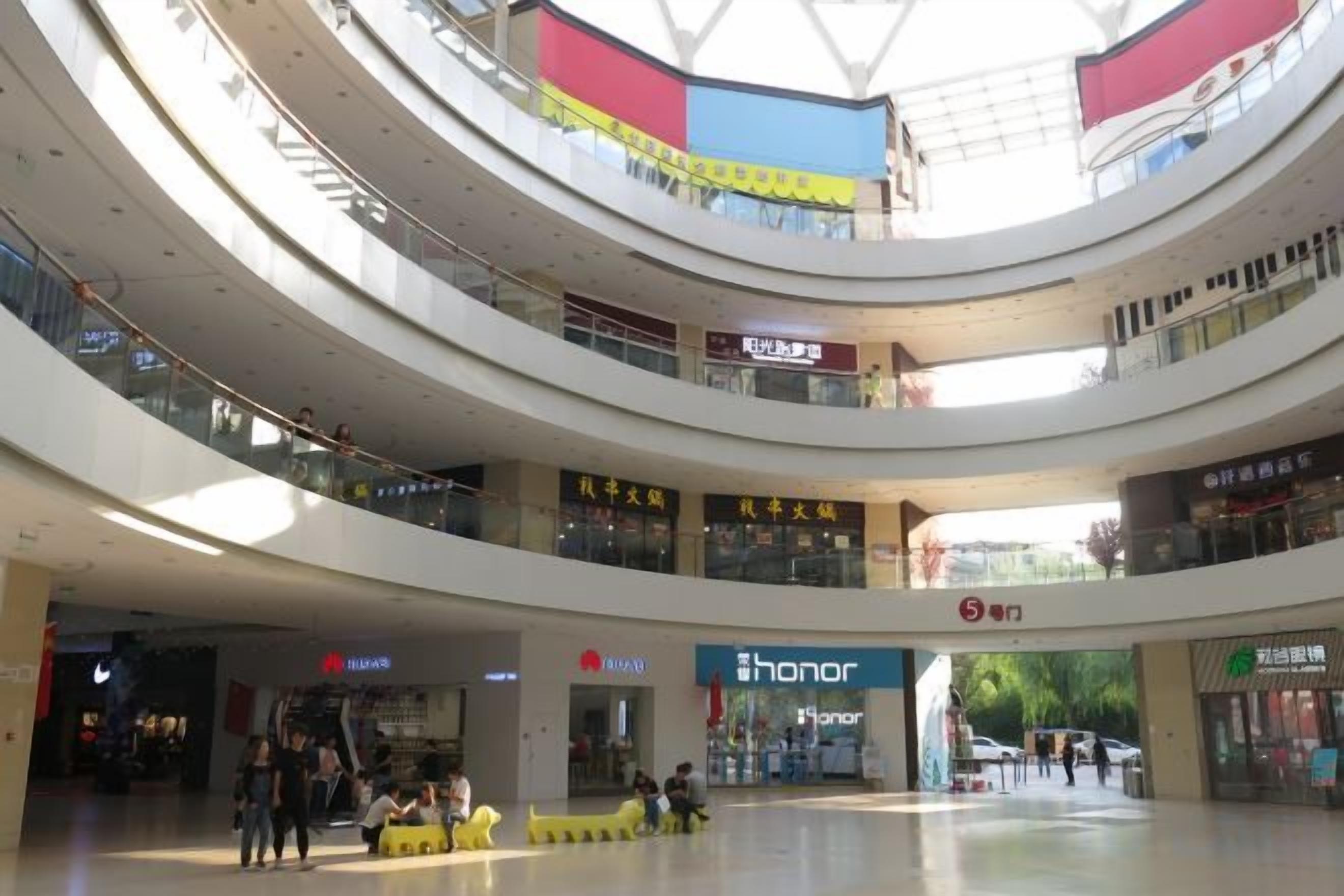 A multi-level shopping mall with various stores, including a visible Honor store.