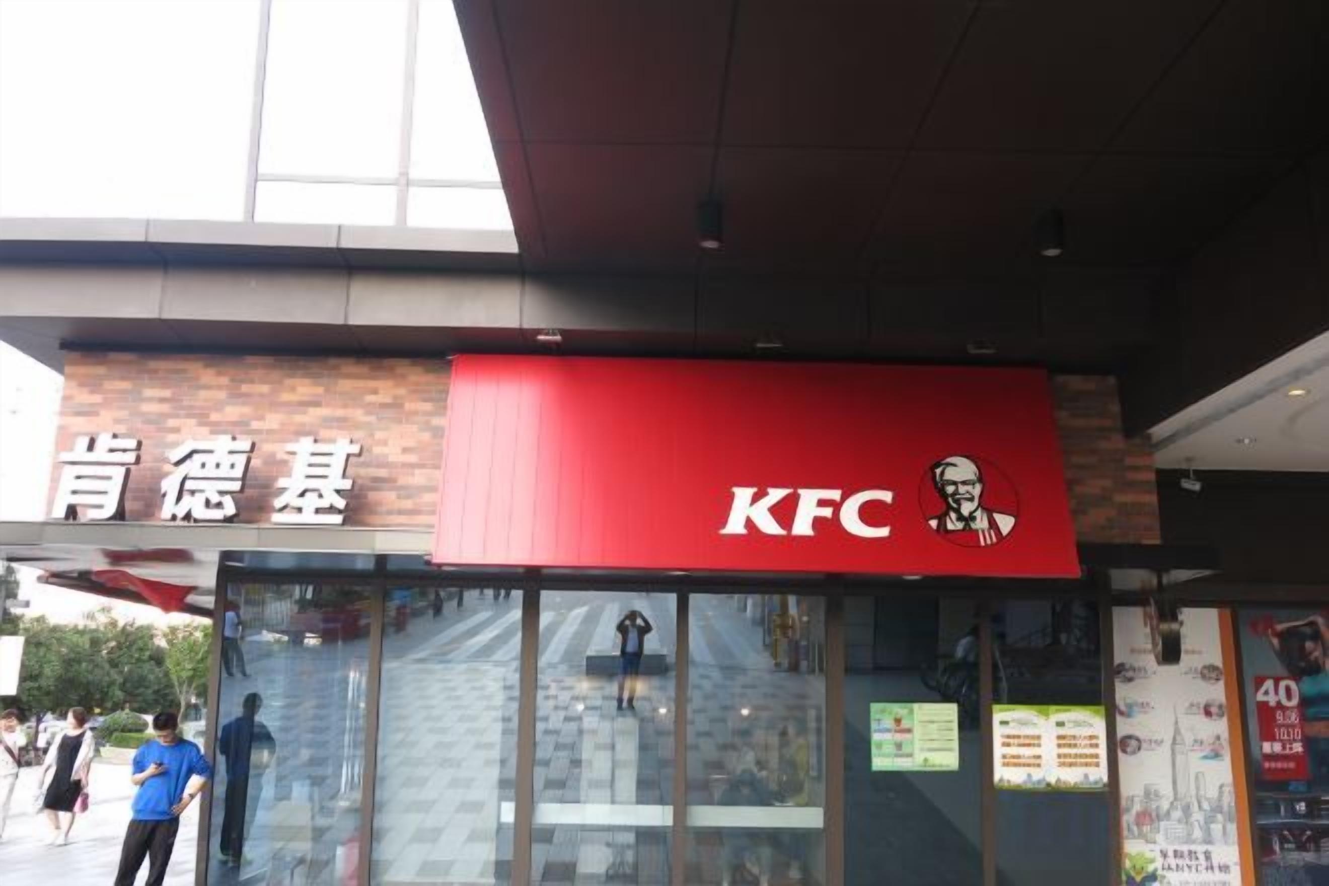 Un restaurante KFC con escaparate de vidrio y letreros en un idioma extranjero.