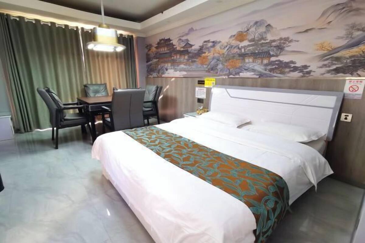 A hotel room with a bed, a desk, and a chair.