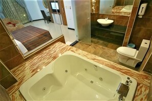 Une salle de bain moderne avec une grande baignoire, un lavabo et des toilettes.