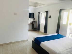 A bedroom with a bed, a desk with a computer, a window with curtains, and a chair. - VISTA Montanha  GOA (Calangute)
