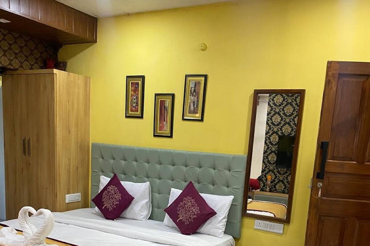 Une chambre bien rangée, avec un lit, une armoire en bois et un miroir au mur.