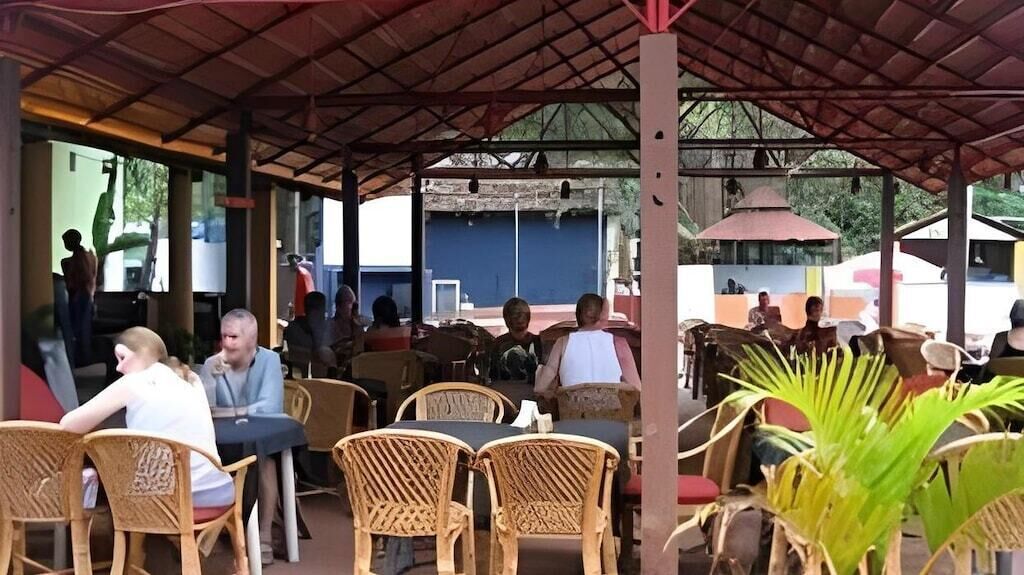 Ein Straßencafé mit Korbstühlen und Tischen, einem überdachten Dach und Blick auf die Straße.