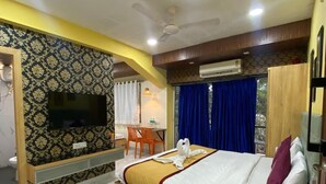 A hotel room with a bed, a TV, a desk, and a chair. - VISTA Montanha  GOA (Calangute)
