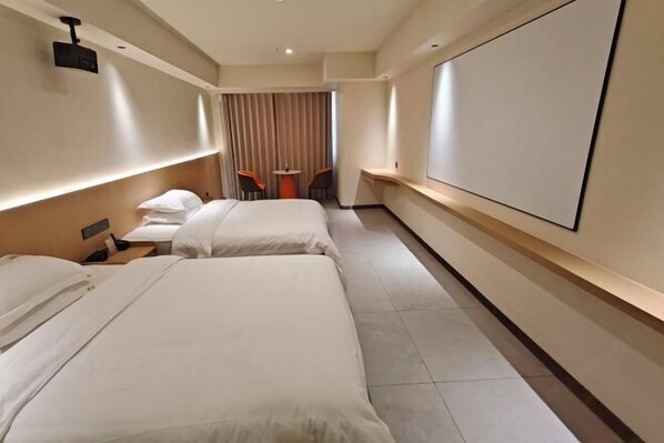 A hotel room with two beds, a desk, a chair, a TV, and a curtain. - Huang Ting Hotel (Jinxian)