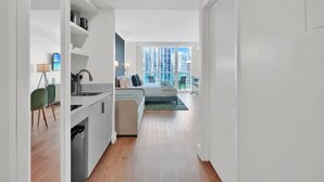 Un apartamento moderno con cocina, comedor y un amplio ventanal con vistas a la ciudad.